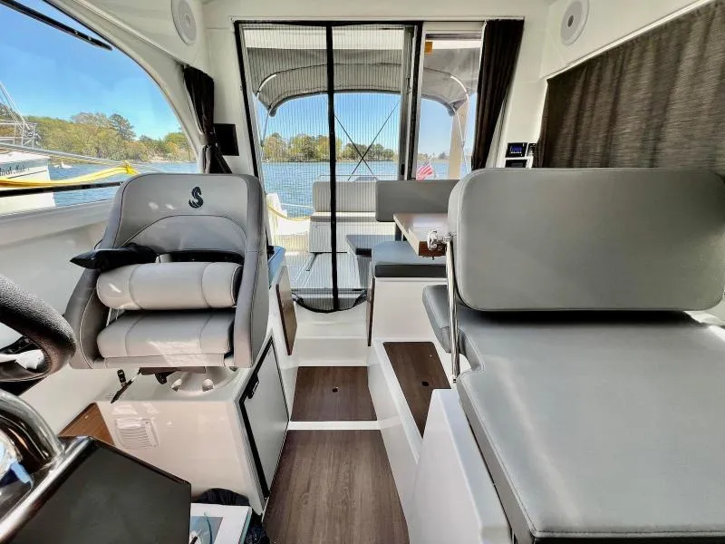 Slide: The Image of Interior of 2023 Beneteau Antares 8 boat, featuring modern seating and scenic water view. - 20