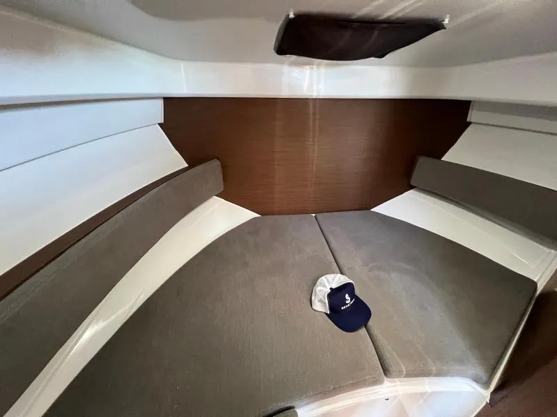 Slide: The Image of 2023 Beneteau Antares 8 cabin interior with cushions and a cap on the bed. - 23