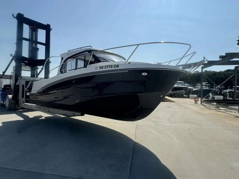 Slide: The Image of 2023 Beneteau Antares 8 boat on a lift at a marina under clear skies. - 3