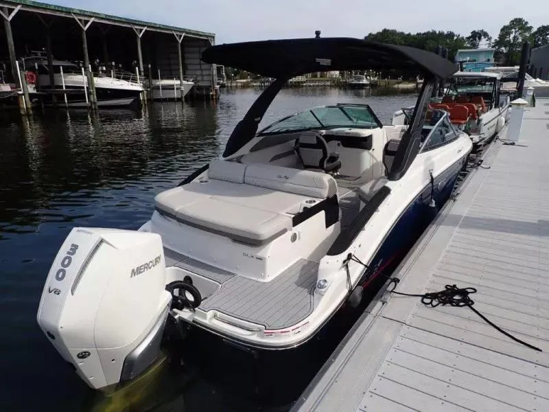 Slide: The Image of 2024 Sea Ray SLX 260 Outboard boat docked, featuring sleek design and powerful Mercury engine. - 10