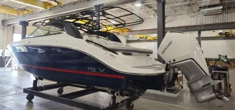 Slide: The Image of 2024 Sea Ray SLX 260 Outboard boat in a warehouse setting. - 3