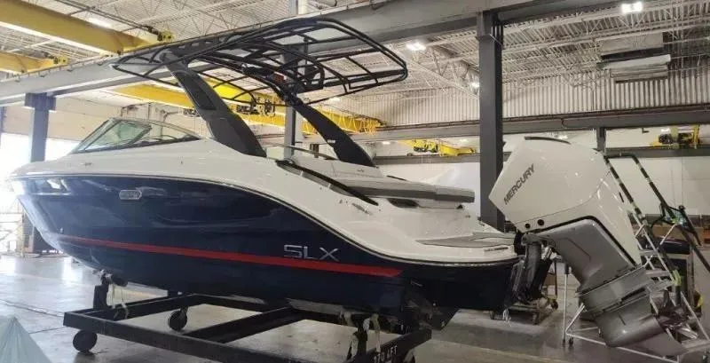 Slide: The Image of 2024 Sea Ray SLX 260 Outboard boat in a warehouse setting. - 4