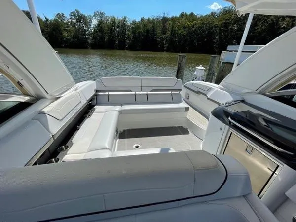 Slide: The Image of 2019 Formula Boats 350 CBR interior with spacious seating, docked by a serene lake. - 15