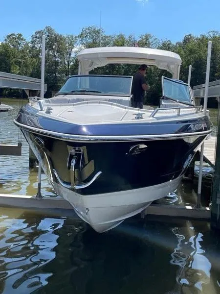 Slide: The Image of 2019 Formula Boats 350 CBR on a lift, docked by a serene lake. - 4
