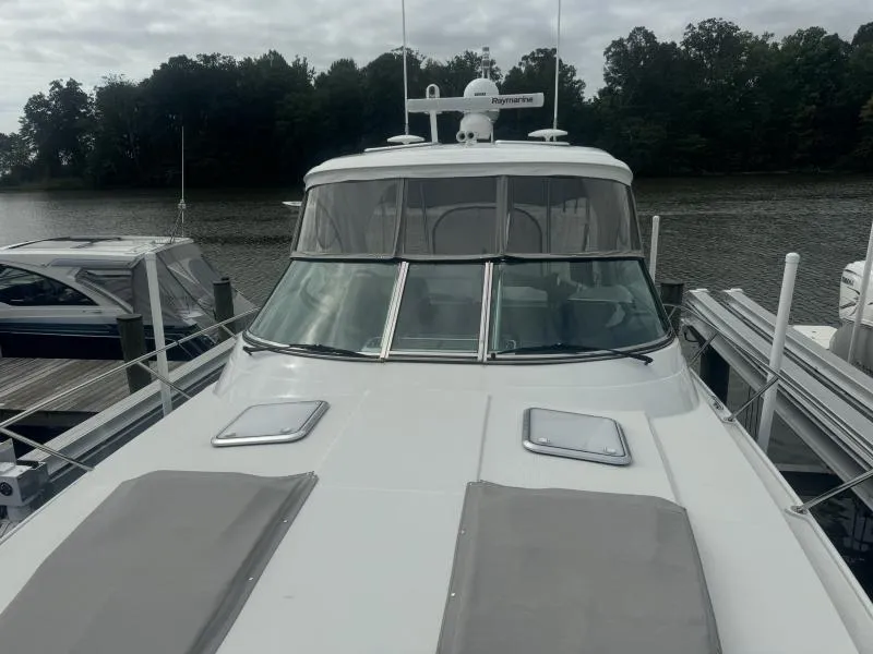 Slide: The Image of 2023 Formula Boats 40 PC docked by a serene lake under cloudy skies. - 10