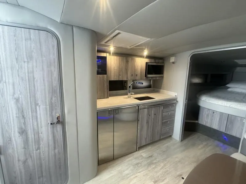 Slide: The Image of 2023 Formula Boats 40 PC interior with modern kitchen and cozy sleeping area. - 12