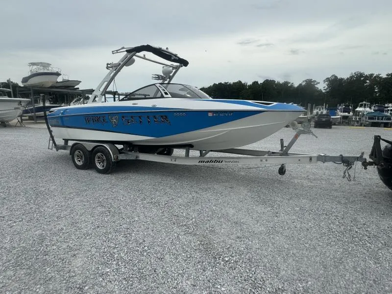 Slide: The Image of 2013 Malibu Wakesetter 23 LSV boat on trailer in marina parking lot. - 1