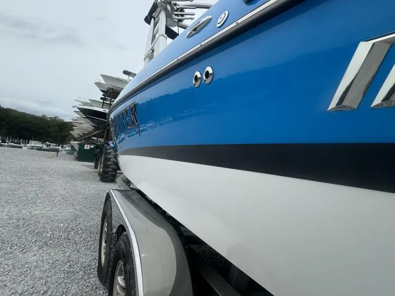Slide: The Image of 2013 Malibu Wakesetter 23 LSV boat on trailer, blue and white design. - 14