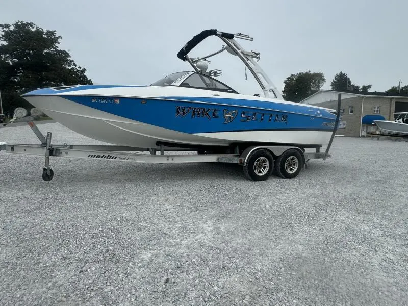 Slide: The Image of 2013 Malibu Wakesetter 23 LSV boat on trailer, blue and white design. - 3