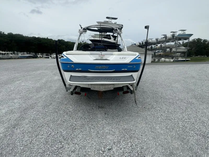Slide: The Image of 2013 Malibu Wakesetter 23 LSV boat parked on gravel lot, rear view. - 6