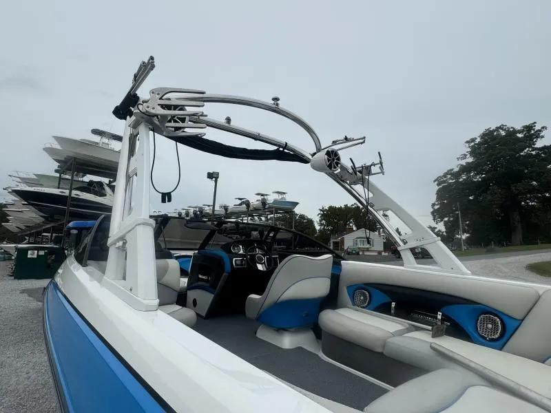 Slide: The Image of 2013 Malibu Wakesetter 23 LSV interior with blue and white seating, parked outdoors. - 7