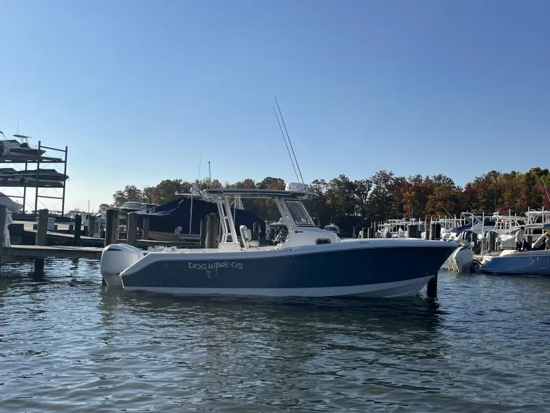 Slide: The Image of 2020 Edgewater 280 Center Console boat docked in a marina under clear blue sky. - 1