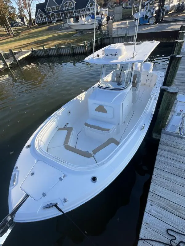 Slide: The Image of 2020 Edgewater 280 Center Console boat docked at marina, featuring sleek design and spacious seating. - 11