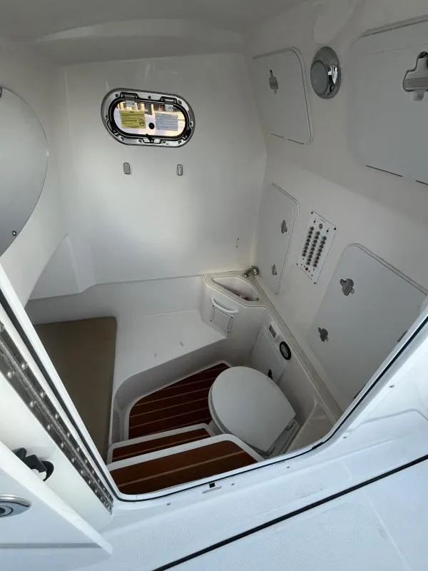 Slide: The Image of 2020 Edgewater 280 Center Console interior with compact marine toilet and sink. - 13
