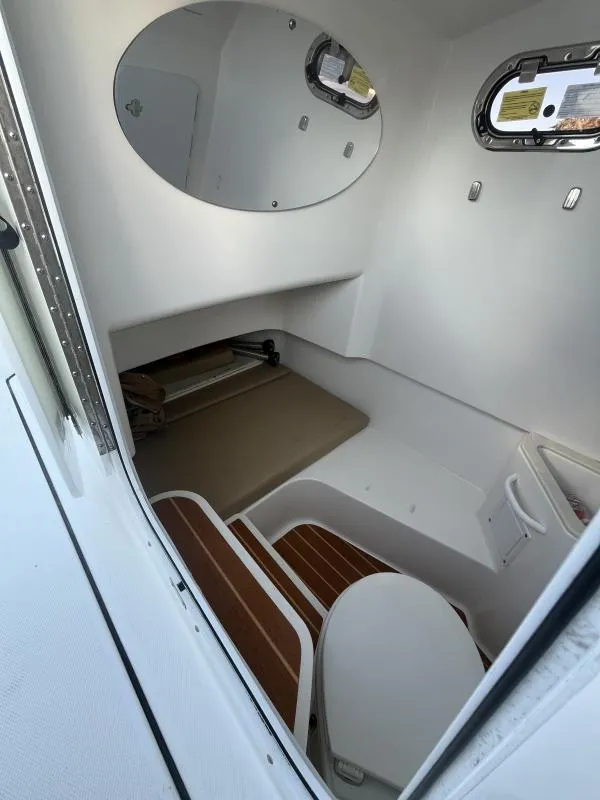 Slide: The Image of 2020 Edgewater 280 Center Console cabin interior with seating and porthole windows. - 14