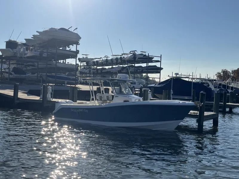 Slide: The Image of 2020 Edgewater 280 Center Console boat docked at marina under clear sky. - 3