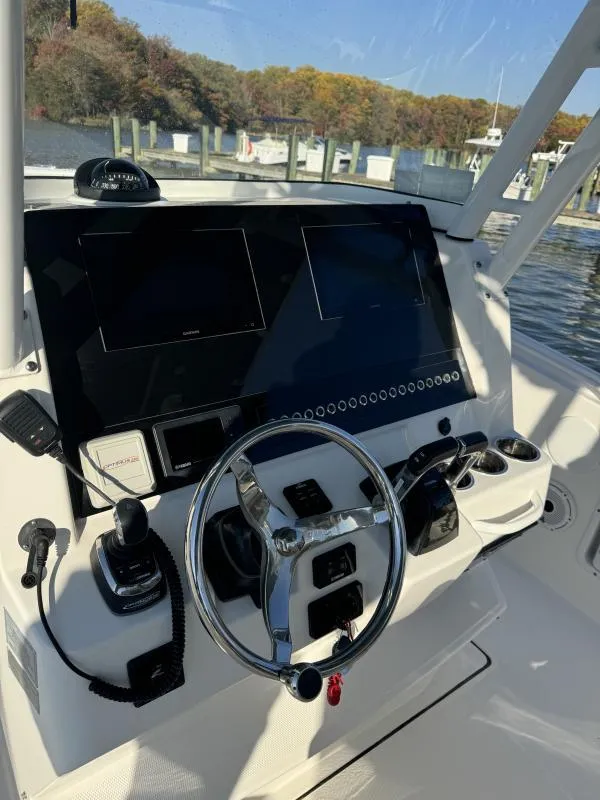 Slide: The Image of Edgewater 280 Center Console 2020 helm with steering wheel and navigation screens. - 7