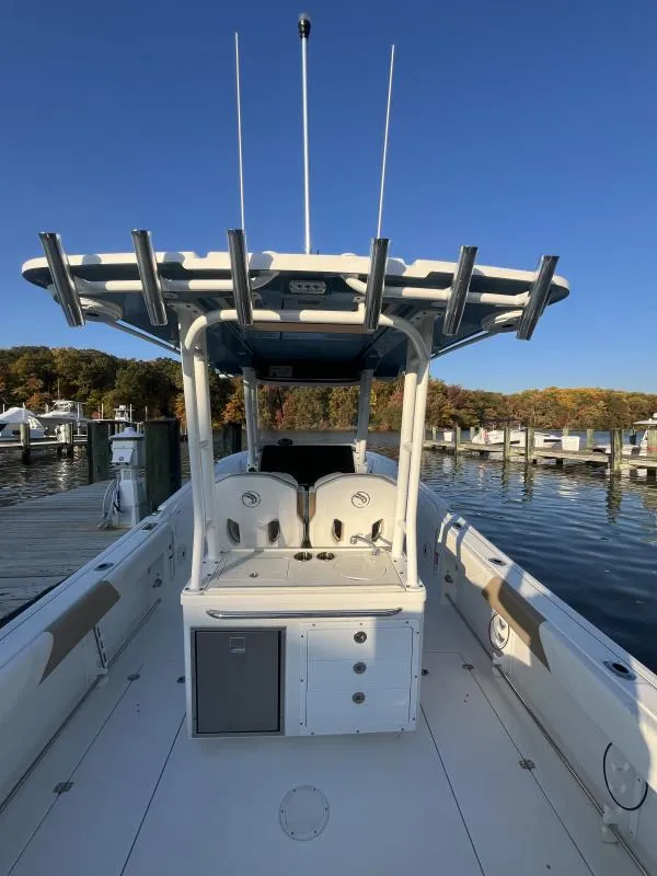 Slide: The Image of 2020 Edgewater 280 Center Console boat docked at marina under clear blue sky. - 8