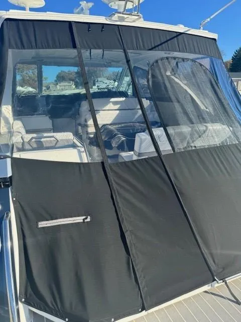 Slide: The Image of 2020 Formula Boats 380 SSC with black canvas cover, docked under clear blue sky. - 11