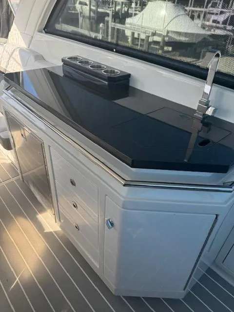 Slide: The Image of 2020 Formula Boats 380 SSC yacht kitchenette with sleek black countertop and modern fixtures. - 15