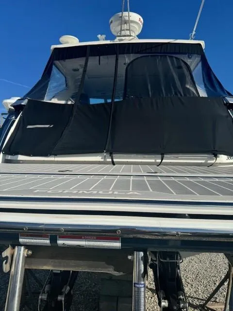 Slide: The Image of 2020 Formula Boats 380 SSC, rear view with covered deck, under clear blue sky. - 9