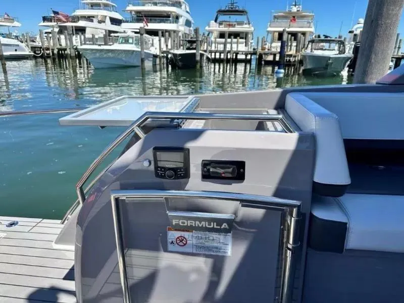 Slide: The Image of 2022 Formula 430 Super Sport Crossover yacht docked at marina with luxury boats. - 10