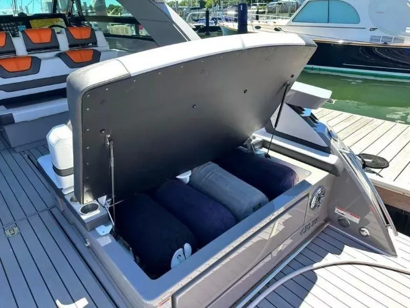 Slide: The Image of Open storage compartment on 2022 Formula 430 Super Sport Crossover boat, docked at marina. - 12