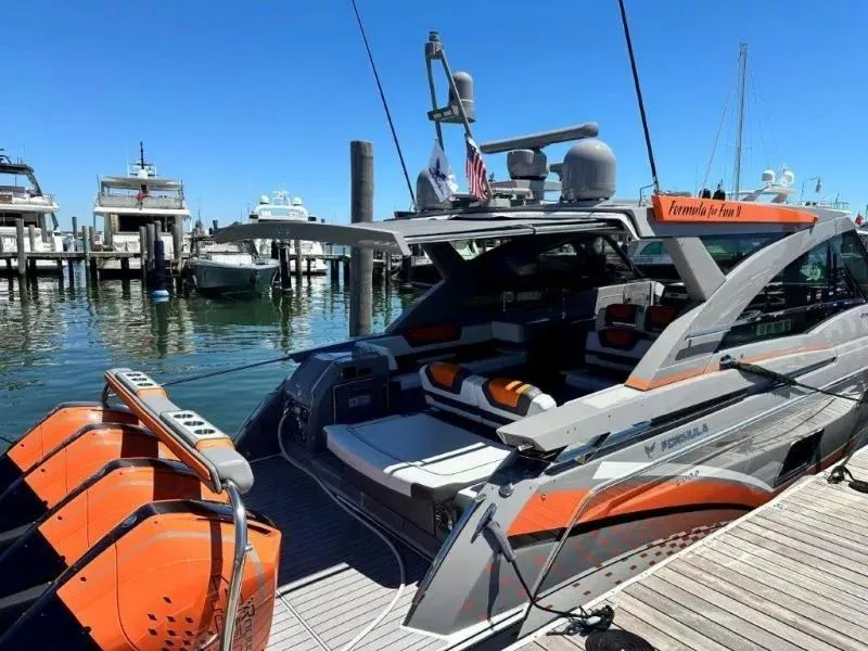 Slide: The Image of 2022 Formula 430 Super Sport Crossover yacht docked at marina with vibrant orange accents. - 14
