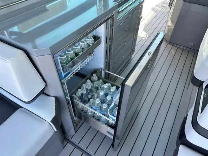 Slide: The Image of Open mini fridge on 2022 Formula 430 Super Sport Crossover, stocked with water bottles. - 7