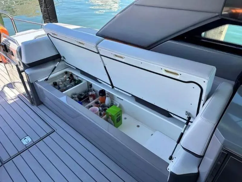 Slide: The Image of 2022 Formula 430 Super Sport Crossover boat with open storage compartment and beverages. - 9