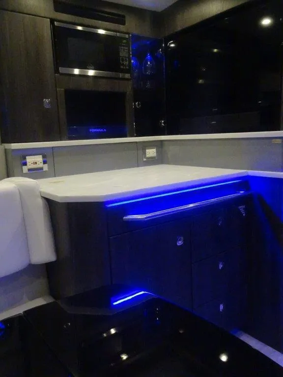 Slide: The Image of 2021 Formula 430 Super Sport Crossover interior with modern kitchen and blue LED lighting. - 15