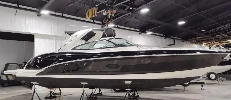 Slide: The Image of 2018 Formula 350 Crossover Bowrider in showroom, sleek design, black and white exterior. - 1