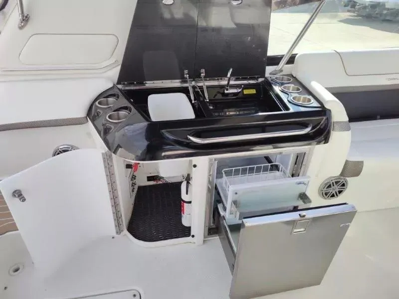 Slide: The Image of 2018 Formula 350 Crossover Bowrider boat kitchen area with sink, storage, and mini fridge. - 19