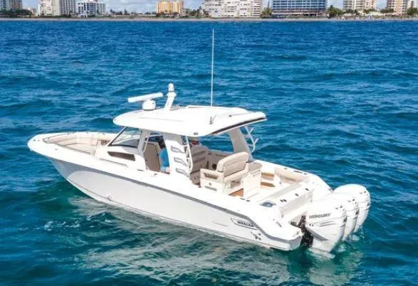 Slide: The Image of 2020 Boston Whaler 350 Realm boat on blue ocean near city skyline. - 1