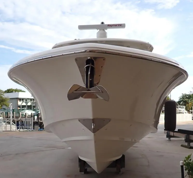 Slide: The Image of 2020 Boston Whaler 350 Realm boat, front view, docked under a clear sky. - 16