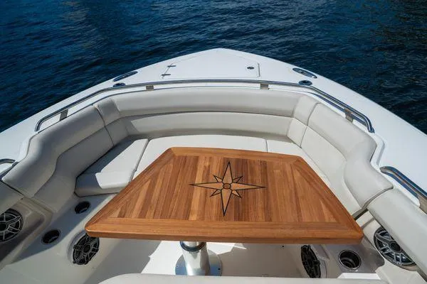 Slide: The Image of Boston Whaler 350 Realm 2020 boat with elegant wooden table and cushioned seating. - 2