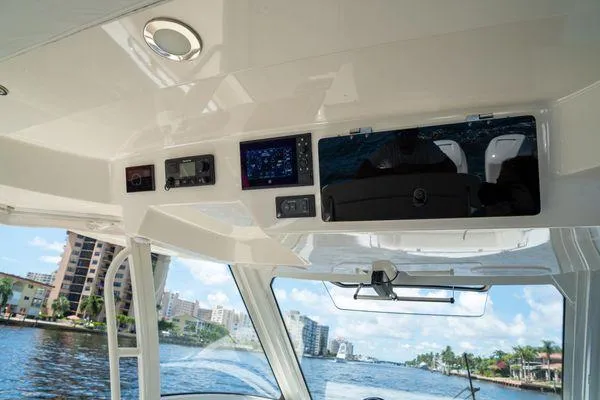 Slide: The Image of 2020 Boston Whaler 350 Realm interior with navigation panel, overlooking waterfront cityscape. - 9