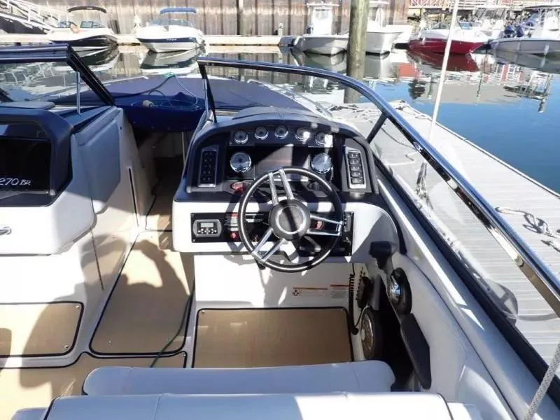 Slide: The Image of 2014 Formula 270 Bowrider boat cockpit with steering wheel and dashboard, docked at marina. - 15