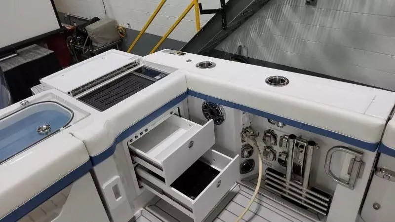 Slide: The Image of 2025 Formula 387 Center Console Fish boat interior with storage drawers and fishing equipment. - 13