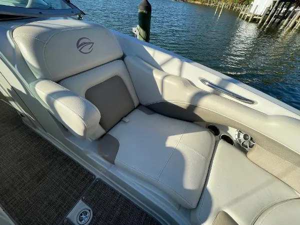 Slide: The Image of 2017 Crownline Eclipse E6 XS boat interior with beige seating by the water. - 14