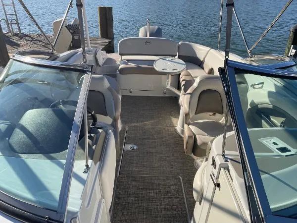 Slide: The Image of 2017 Crownline Eclipse E6 XS boat interior with seating and table, docked by the water. - 16