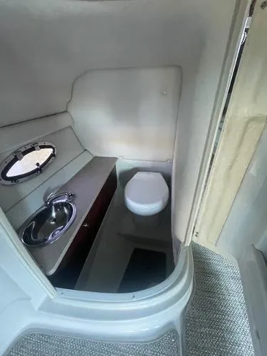 Slide: The Image of 2017 Crownline Eclipse E6 XS boat interior with compact bathroom, sink, and toilet. - 19