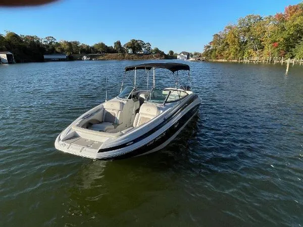 Slide: The Image of 2017 Crownline Eclipse E6 XS boat on a calm lake with trees in the background. - 6
