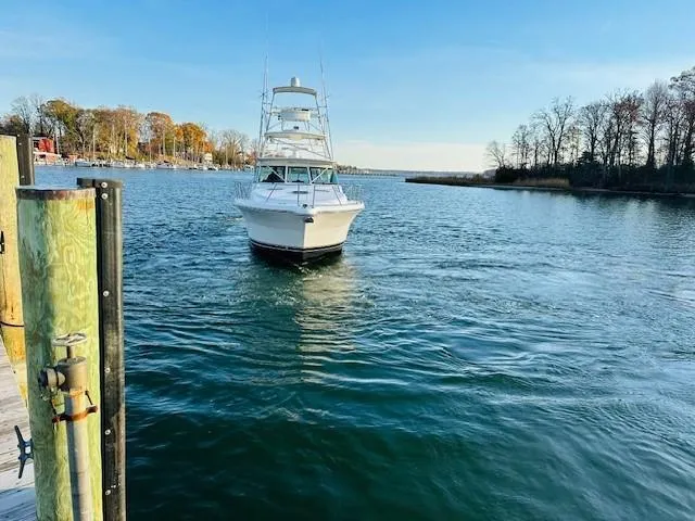 Slide: The Image of 2004 Tiara Sport 4200 Open yacht on a calm lake near a dock. - 10
