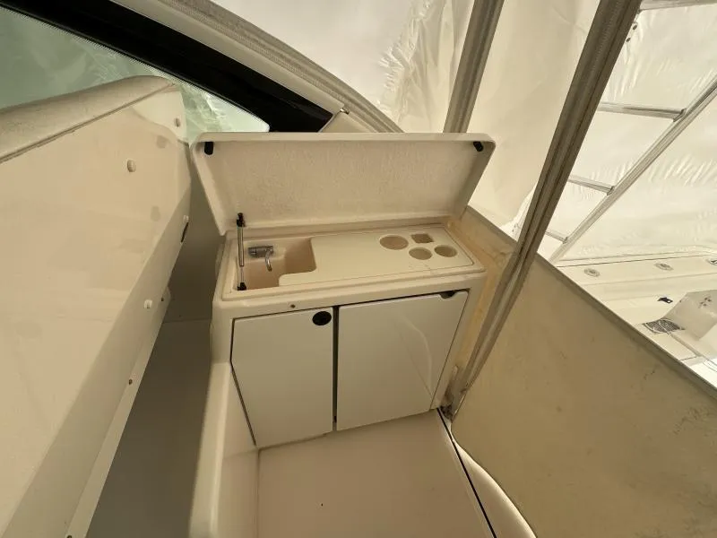 Slide: The Image of 2004 Tiara Sport 4200 Open yacht interior with compact kitchenette and storage. - 19