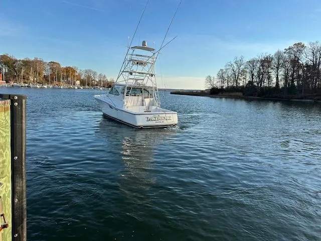 Slide: The Image of 2004 Tiara Sport 4200 Open yacht on calm water, surrounded by trees. - 4