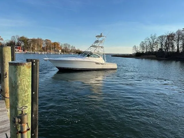 Slide: The Image of 2004 Tiara Sport 4200 Open yacht on calm water near a dock. - 5