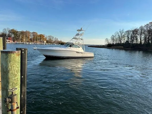 Slide: The Image of Tiara Sport 4200 Open 2004 yacht on calm water, surrounded by trees and clear sky. - 6