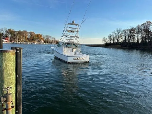 Slide: The Image of 2004 Tiara Sport 4200 Open yacht on calm water near a wooded shoreline. - 8