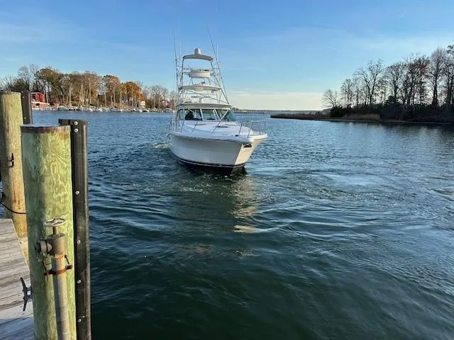 Slide: The Image of Tiara Sport 4200 Open 2004 yacht cruising on a serene lake near a dock. - 9